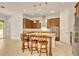 Kitchen with stone countertops, stainless steel appliances, wooden cabinets, breakfast bar, and pendant lighting at 14078 Alafaya Oak Bnd, Orlando, FL 32828