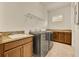 Bright laundry room features a sink with granite countertop, cabinets, and a modern washer and dryer at 14078 Alafaya Oak Bnd, Orlando, FL 32828