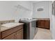 Functional laundry room with granite counters, cabinetry, utility sink and modern washer and dryer at 14078 Alafaya Oak Bnd, Orlando, FL 32828