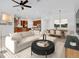Staged living room showcasing neutral decor, a modern sofa, and adjacent dining and kitchen areas at 14078 Alafaya Oak Bnd, Orlando, FL 32828