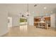 Open-concept living space with chandelier and tile flooring seamlessly connects to a modern kitchen at 14078 Alafaya Oak Bnd, Orlando, FL 32828