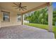Covered patio with brick pavers, ceiling fan, and view of fenced yard at 14078 Alafaya Oak Bnd, Orlando, FL 32828