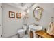 Powder room featuring a pedestal sink, decorative mirror, and charming wall sconces at 1441 Sunnyside Dr, Maitland, FL 32751