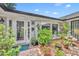 Inviting front entrance with a glass door, large window and abundant greenery in a charming garden setting at 1441 Sunnyside Dr, Maitland, FL 32751