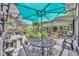 Outdoor setting with a dining table, a grill, a large umbrella and seating surrounded by plants and greenery at 1441 Sunnyside Dr, Maitland, FL 32751