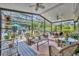 Spacious screened porch featuring multiple seating arrangements and lush, landscaped surroundings at 1441 Sunnyside Dr, Maitland, FL 32751