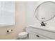 Bright bathroom featuring a round mirror, shiplap wall, and modern fixtures with a toilet and window at 14655 Erice Ave, Clermont, FL 34714