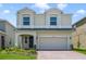 Charming two-story home boasts a well-manicured lawn and a brick driveway leading to a two-car garage at 14655 Erice Ave, Clermont, FL 34714