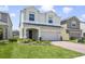 Charming two-story home boasts a well-manicured lawn and a brick driveway leading to a two-car garage at 14655 Erice Ave, Clermont, FL 34714
