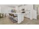 Bright kitchen featuring an island with seating, stainless appliances, and white cabinetry at 14655 Erice Ave, Clermont, FL 34714