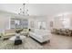 Bright living room with stylish sofas, a modern chandelier, and seamless transition to the dining area at 14655 Erice Ave, Clermont, FL 34714
