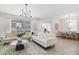 Open-concept living area showcasing stylish sofas, modern lighting, and access to the office and dining at 14655 Erice Ave, Clermont, FL 34714
