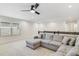 Inviting living room featuring a large gray sectional sofa, ceiling fan, and natural light from the window at 14655 Erice Ave, Clermont, FL 34714