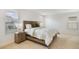 Comfortable bedroom with a bed, nightstand, carpet flooring, and natural light from the window at 14655 Erice Ave, Clermont, FL 34714