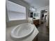 Bathroom with garden tub, vanity and natural light at 14936 Masthead Landing Cir, Winter Garden, FL 34787