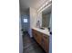 Bathroom featuring wood-look floors, wood cabinets and drawers, and a large mirror at 14936 Masthead Landing Cir, Winter Garden, FL 34787