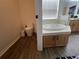 Bathroom with a commode next to the corner soaking tub with wood cabinets at 14936 Masthead Landing Cir, Winter Garden, FL 34787