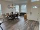 Bright dining room featuring wood-look floors, chandelier, and front door view at 14936 Masthead Landing Cir, Winter Garden, FL 34787