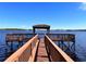 Lakeside wooden dock leads to covered gazebo with seating and amazing views at 14936 Masthead Landing Cir, Winter Garden, FL 34787