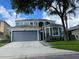 Charming two-story home featuring a two-car garage, gray facade, and manicured landscaping at 14936 Masthead Landing Cir, Winter Garden, FL 34787