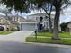 Charming two-story home featuring a two-car garage, gray facade, and manicured landscaping at 14936 Masthead Landing Cir, Winter Garden, FL 34787