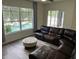 Bright living room featuring a leather sectional sofa and backyard pool views at 14936 Masthead Landing Cir, Winter Garden, FL 34787