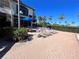 A serene pool deck with comfortable lounge chairs under blue umbrellas surrounded by lush landscaping at 14936 Masthead Landing Cir, Winter Garden, FL 34787
