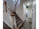 Carpeted staircase with white railing and wood banister in a light-filled foyer at 14936 Masthead Landing Cir, Winter Garden, FL 34787