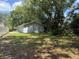 The backyard has luscious green grass and is surrounded by an abundance of trees at 1523 S Mellonville Ave, Sanford, FL 32771