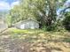View of shady backyard showing trees and grass at 1523 S Mellonville Ave, Sanford, FL 32771