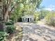 Charming home exterior with a paved driveway and surrounding lush greenery at 1523 S Mellonville Ave, Sanford, FL 32771