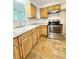 A practical kitchen featuring wooden cabinets, granite countertops, and modern stainless-steel appliances at 1523 S Mellonville Ave, Sanford, FL 32771