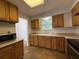Bright kitchen featuring wooden cabinets, stone countertops, and a double sink at 1523 S Mellonville Ave, Sanford, FL 32771