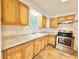 Well-lit kitchen featuring wooden cabinets, stone countertops, and modern stainless-steel appliances at 1523 S Mellonville Ave, Sanford, FL 32771