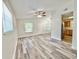 Bright, open living area features wood-look floors, ceiling fan, and ample natural light from large windows at 1523 S Mellonville Ave, Sanford, FL 32771