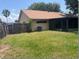 Fenced backyard featuring green lawn, access to screened in porch, and mature trees at 1606 Red Clover Ct, Orlando, FL 32825