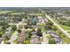 Panoramic aerial shot of a residential area with ponds, nearby commercial buildings, and lush greenery under a bright sky at 1614 Christa Ct, St Cloud, FL 34772