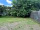 Large backyard with mature trees and privacy fence, offering ample space for outdoor activities at 1614 Christa Ct, St Cloud, FL 34772