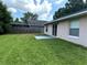Backyard featuring a grassy lawn, patio, privacy fence, and mature trees, perfect for outdoor relaxation and entertaining at 1614 Christa Ct, St Cloud, FL 34772