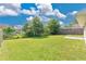 Backyard featuring grass, trees, a fence and partial views of the neighboring homes at 1614 Christa Ct, St Cloud, FL 34772