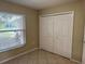 Bedroom with tile flooring, closet space, and a window overlooking the front yard at 1614 Christa Ct, St Cloud, FL 34772