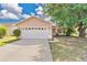 Charming single-story home with a two-car garage, well-maintained lawn, and mature shade tree at 1614 Christa Ct, St Cloud, FL 34772