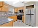 Modern kitchen featuring stainless steel appliances, tile flooring, and granite countertops at 1614 Christa Ct, St Cloud, FL 34772