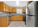 Bright kitchen features stainless steel appliances, wood cabinets, granite countertops, and tile floors at 1614 Christa Ct, St Cloud, FL 34772