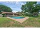 Expansive backyard featuring a sparkling pool, lush landscaping, and mature trees at 1830 W Clinton Dr, St Cloud, FL 34769