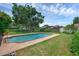 Backyard view showcasing the refreshing in-ground swimming pool and lush landscaping at 1830 W Clinton Dr, St Cloud, FL 34769
