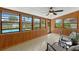 Bright sunroom featuring wood paneling, tiled floors, and large windows overlooking the pool at 1830 W Clinton Dr, St Cloud, FL 34769