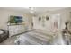 Bright bedroom with wood-look floors, ceiling fan, adjacent bathroom, and decorative wall art at 2113 Kirkland Lake Dr, Auburndale, FL 33823