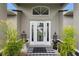 Close up of a charming front door with decorative plants and a welcome mat at 2113 Kirkland Lake Dr, Auburndale, FL 33823