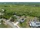 Aerial view of a home with solar panels, a long driveway, and a spacious backyard surrounded by lush greenery at 2135 E Old Mill Dr, Deltona, FL 32725